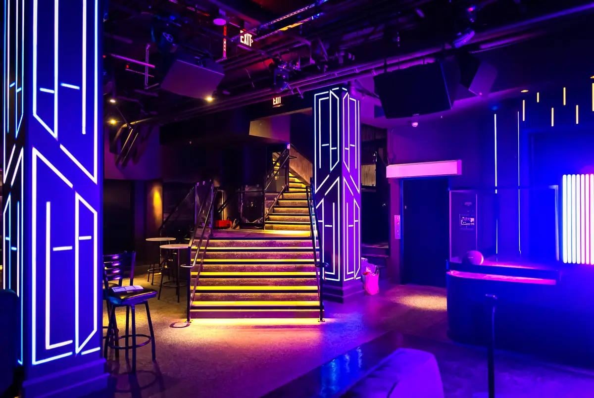 The amber-lit staircase and neon columns at the heart of West 8