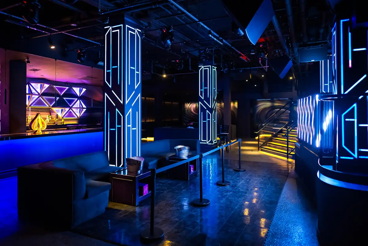 The blue-lit lounge and bar at West 8, neon columns and geometric LED wall