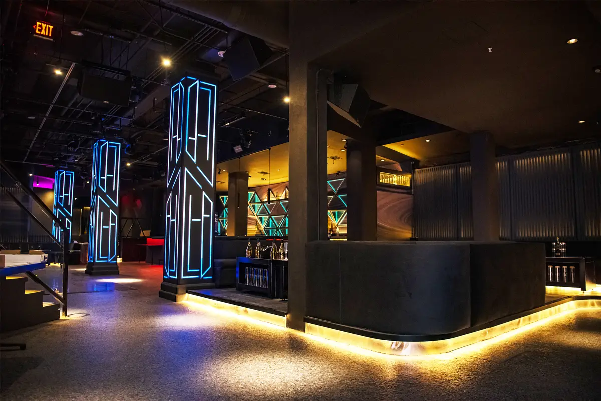 The main floor at West 8: neon columns and a wraparound banquette island
